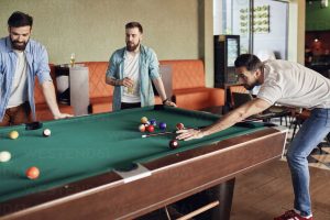 Friends playing billiards together