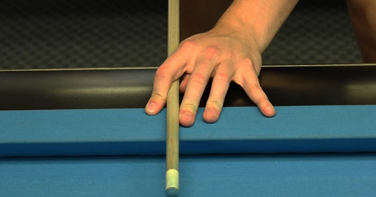 Position your hand and cue stick on the rail in rail bridge 